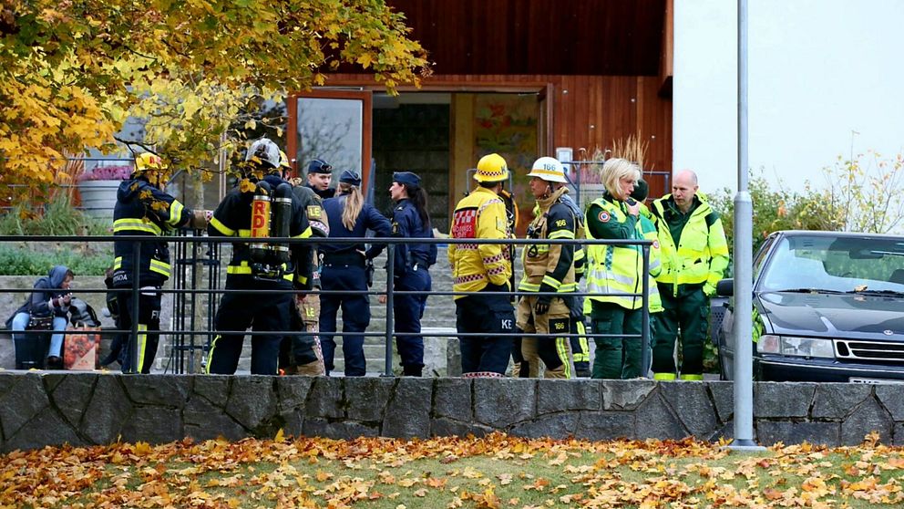 Räddningspersonal står utanför en dörr i Hässelby