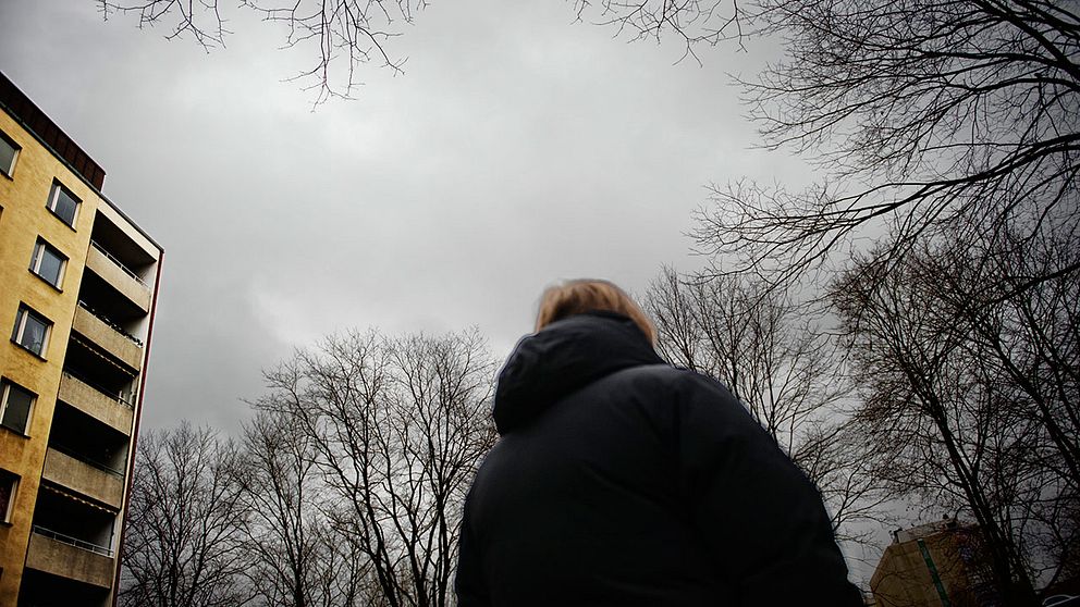 anonym kvinna under mörkgrå himmel.