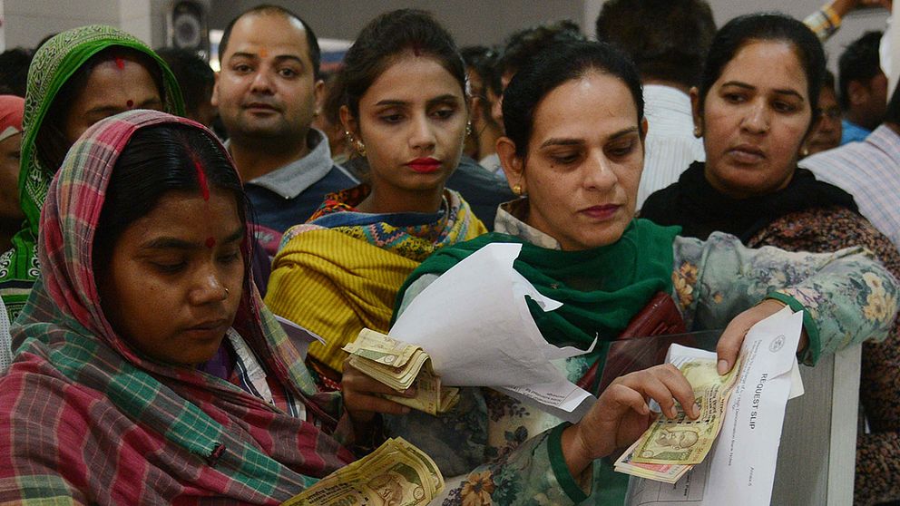 Indier växlar in sedlar på en bank i Amritsar i Indien.