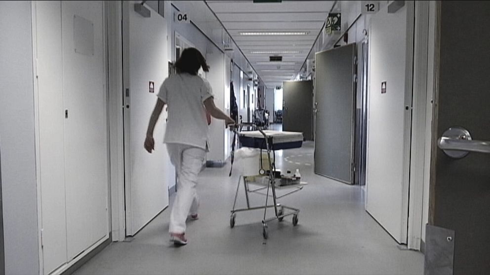 sjuksköterska går med vagn i korridor