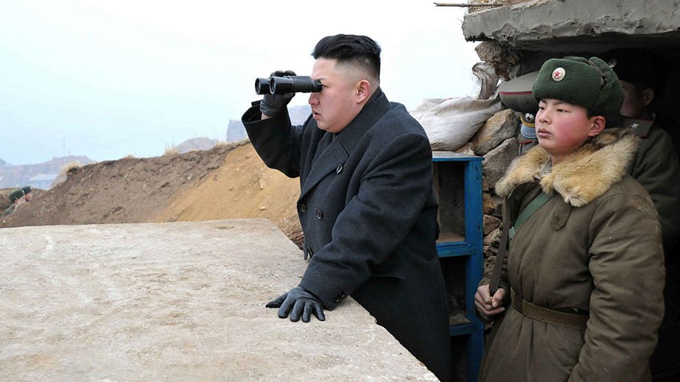 Kim Jong-Un tittar mot den sydkoreanska gränsen med ett par kikare.