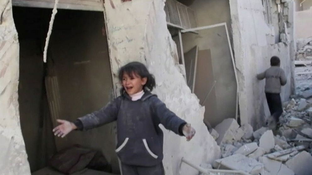 Barnen räddas från sönderbombat hus i Aleppo