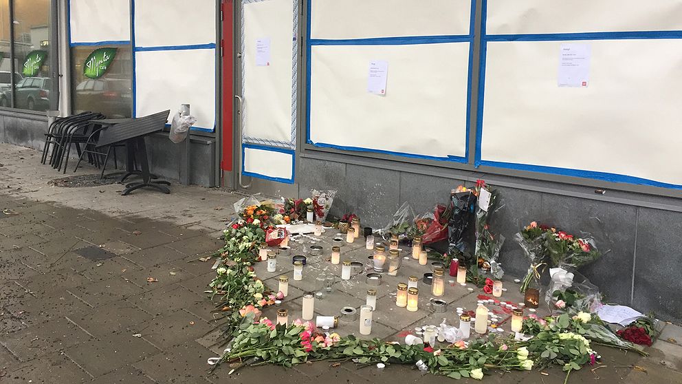 Blommor lagda i en hjärtformation utanför caféet där dödsskjutningarna ägde rum.