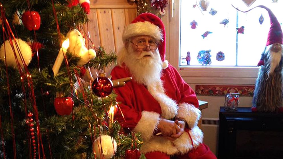 Värmlandstomten sitter vid en julgran.