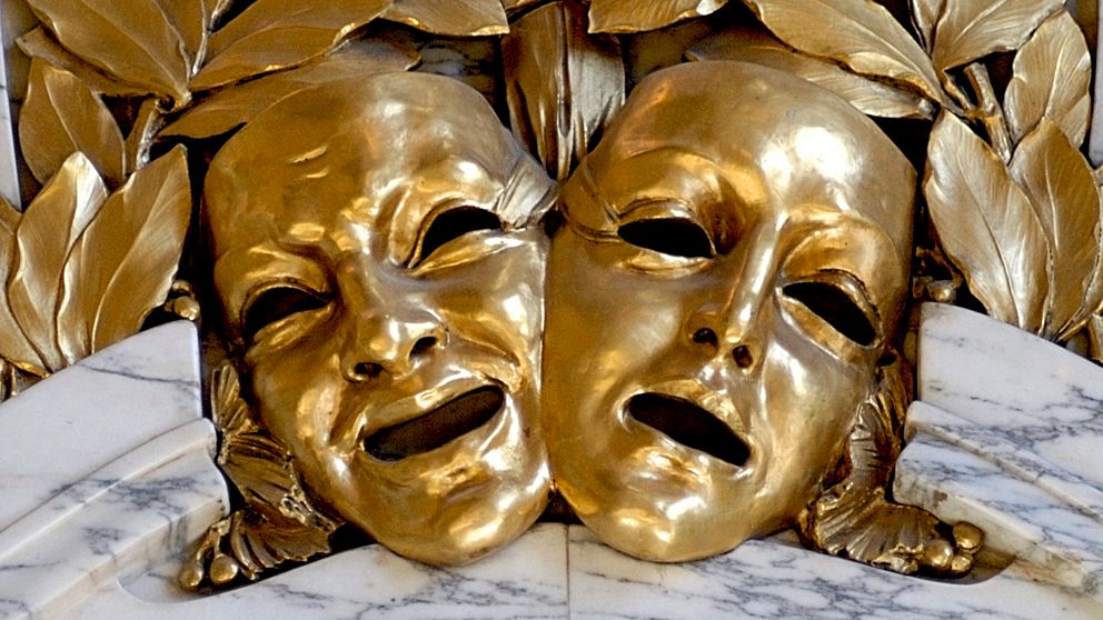 teatermasker i guld som utsmyckning på vägg