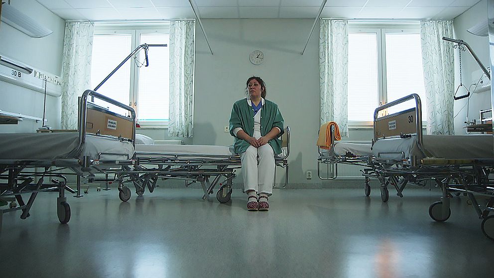 Undersköterskan Lorena Ramos sitter i en tom sal på Nyköpings lasarett, där det i dagsläget finns 31 stängda vårdplatser på grund av personalbrist.