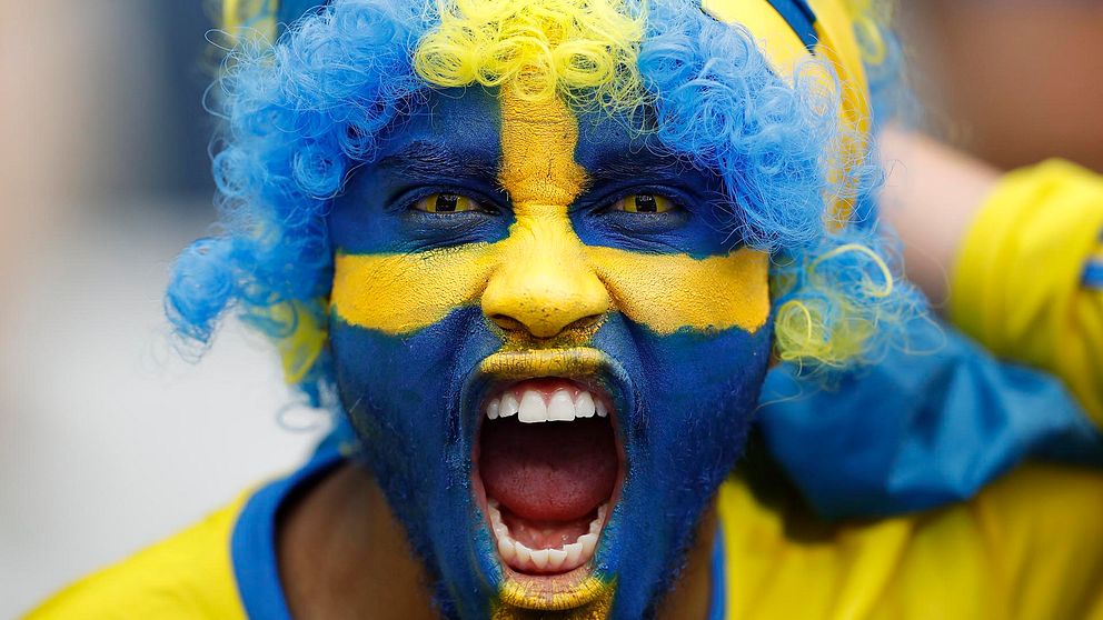 En man med svenska flaggan målad i ansiktet.