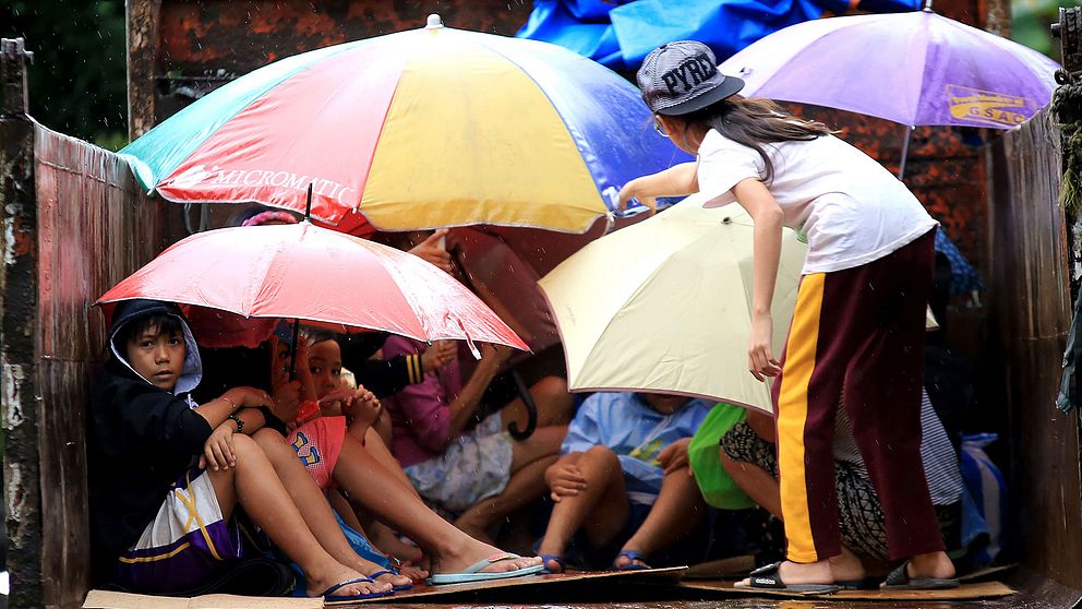 Barn har samlats på ett lastbilsflak under evakueringen av delar av Filippinerna.