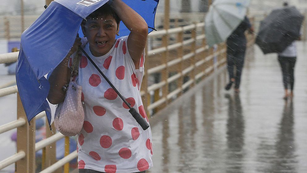 Människor trotsar ovädret i Paranaque, sydost om Manilla i Filippinerna.