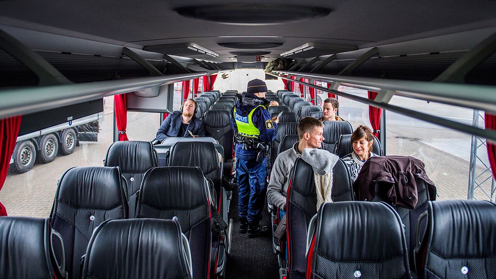 Polis utför en kontroll av id-handlingar på en buss som tar passagerare mellan Danmark och Sverige.