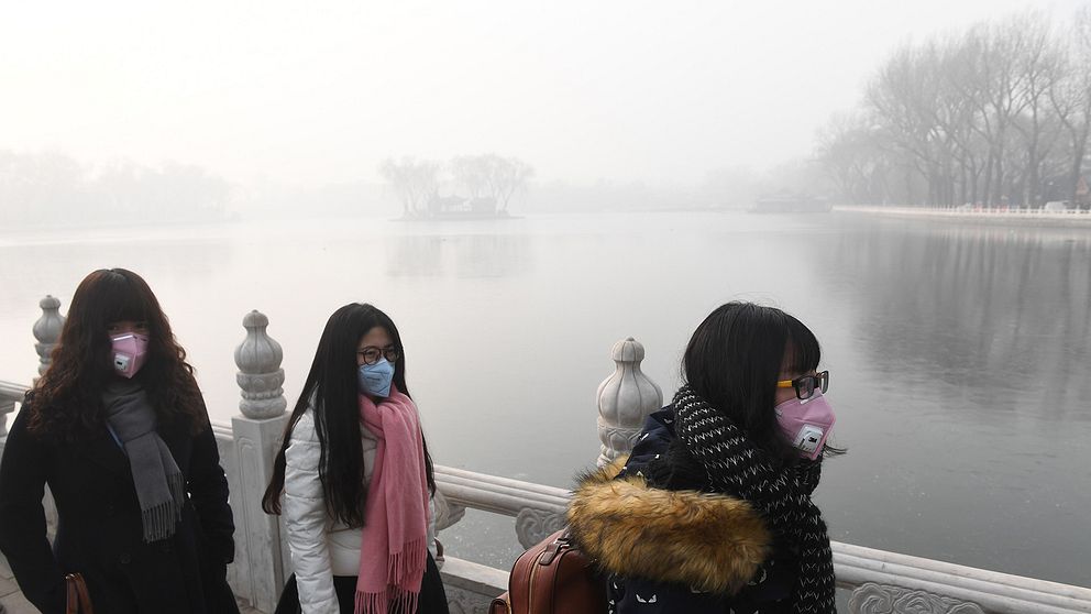 Kvinnor med munskydd i Peking 1 januari 2017 när staden åter drabbades av kraftiga luftföroreningar.