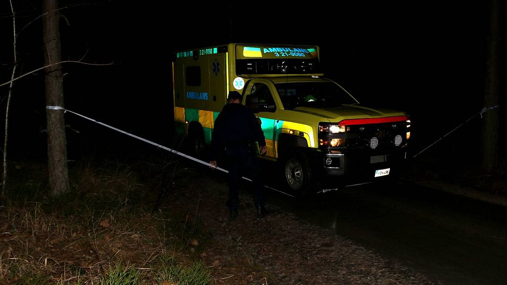 Ambulans på skogsväg i mörker