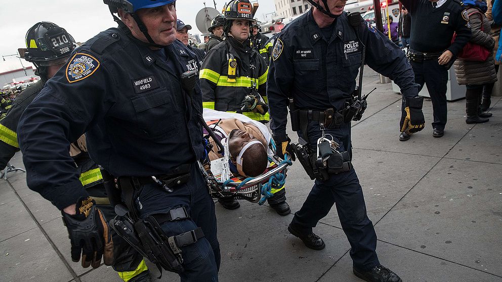 Räddningstjänsten bär i väg en skadad person från olycksplatsen.