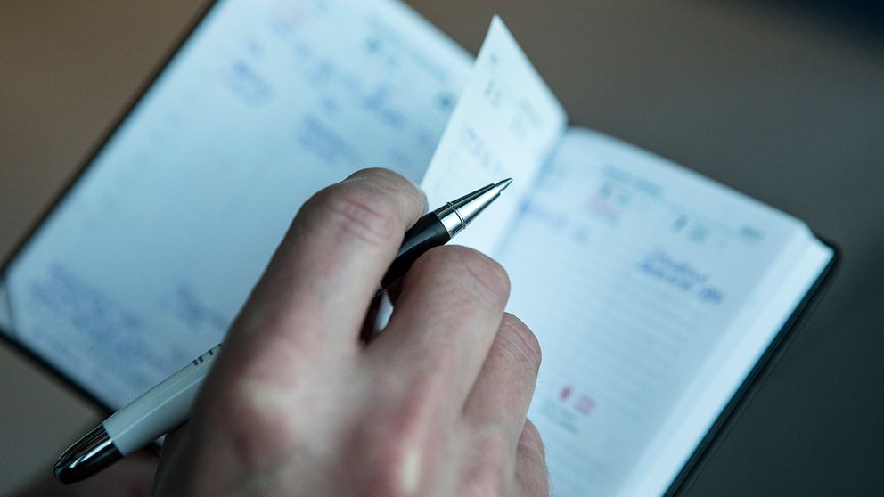 En hand som antecknar i en kalender