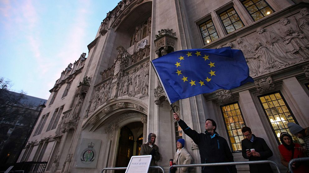 En man viftar med EU-flaggan utanför Storbritanniens högsta domstol i London.