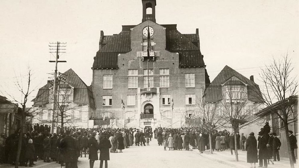 Gammal bild på Strömstads stadshus med mycket folk i förgrunden.