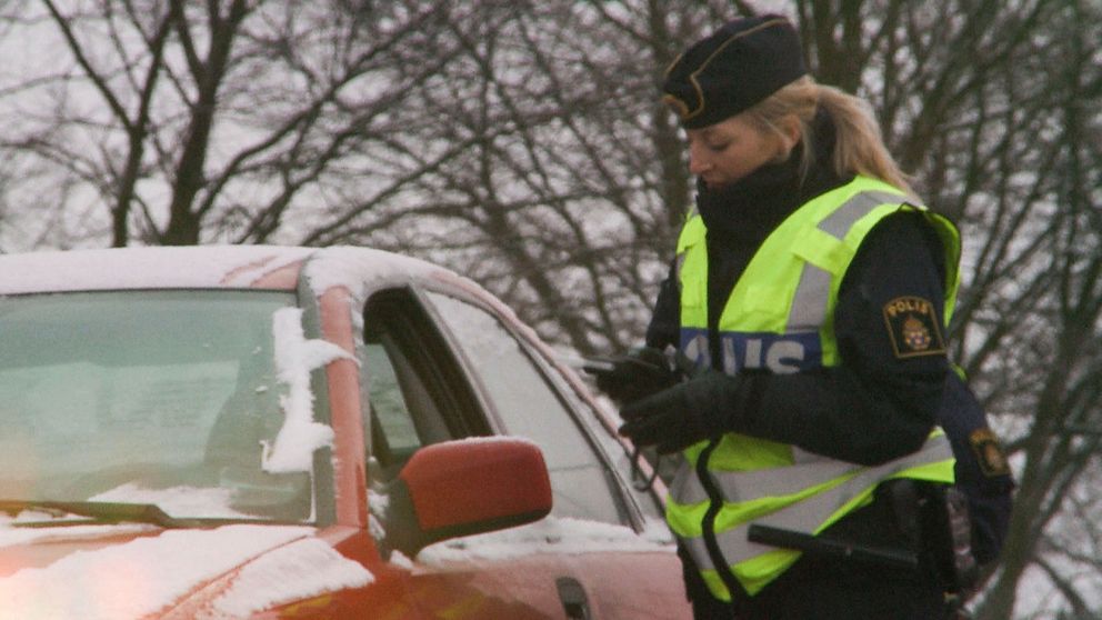 Polis som kontrollerar en bilist.