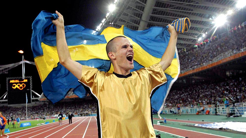 Här jublar Stefan Holm efter sitt OS-guld i höjdhopp på 2.36 och springer ärevarv runt OS-arenan i Aten med den svenska flaggan