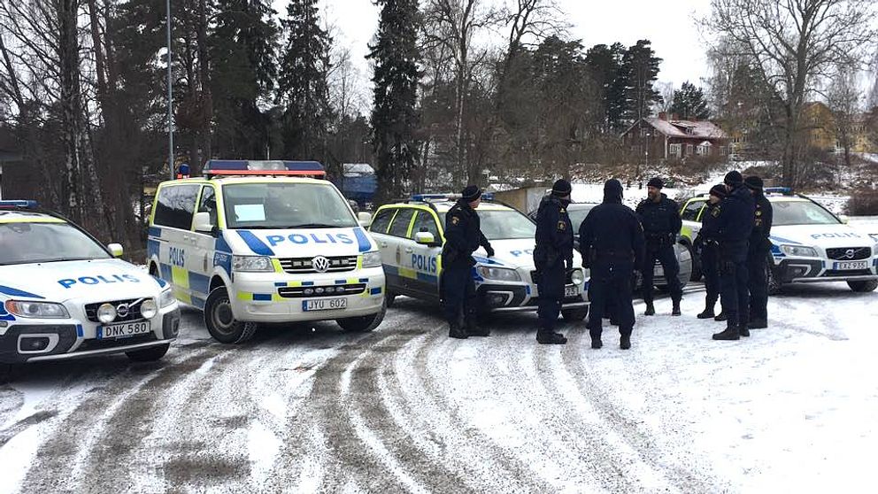 Flera polisbilar och poliser vid en snötäckt parkering i Dals Långed.