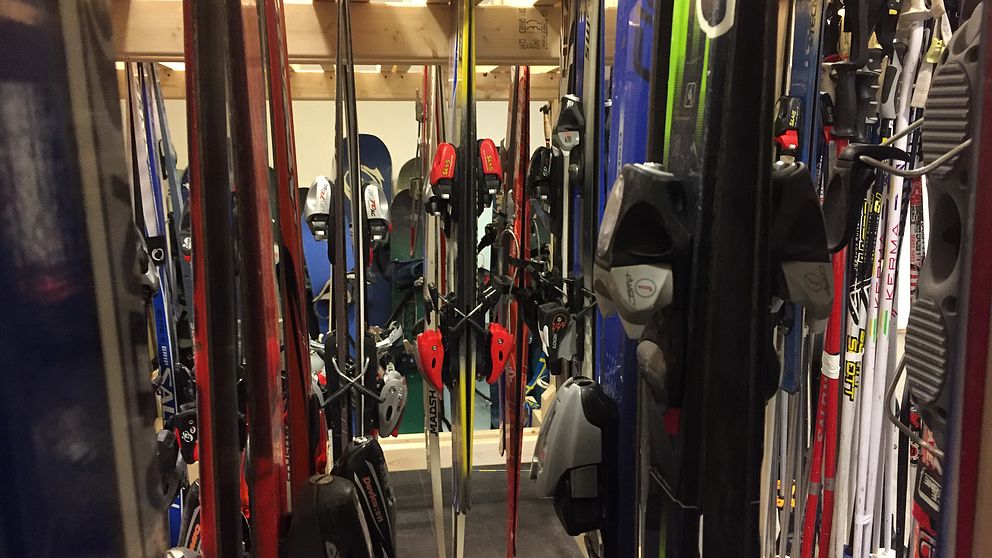 Slalomskidor med bindningar som står par om par i hylla.