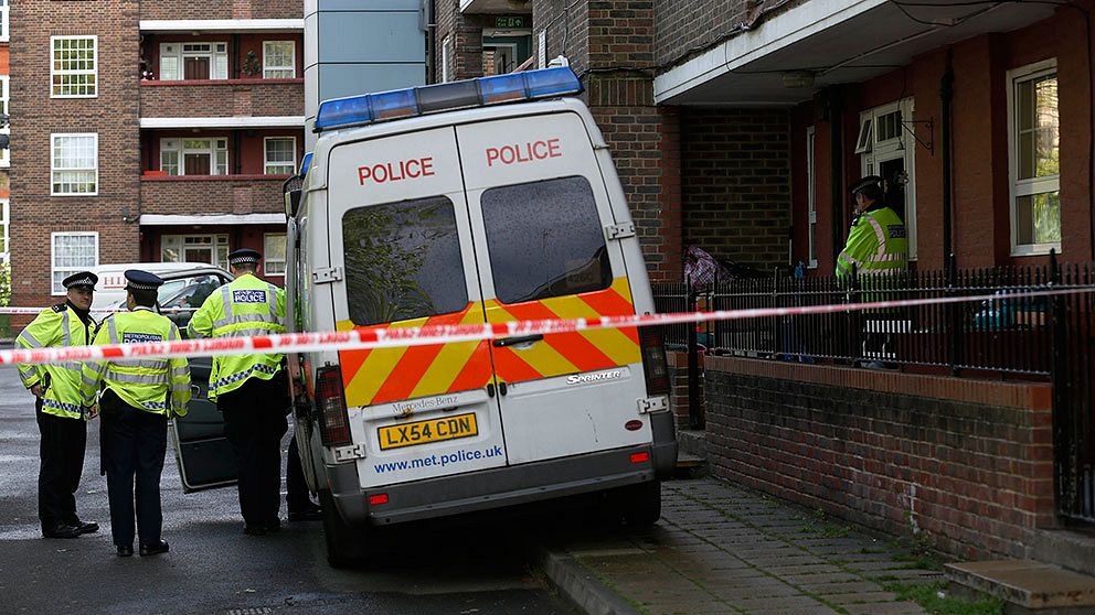 Polisen håller vakt utanför en lägenhet i sydöstra London där det pågår en husrannsakan.