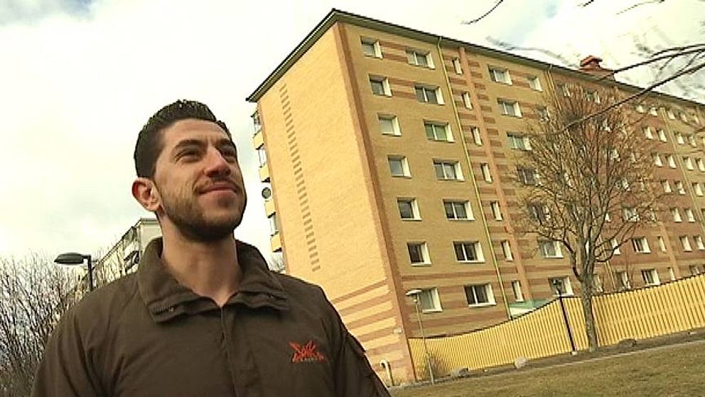 Charbel Mousa går framför ett flerfamiljshus