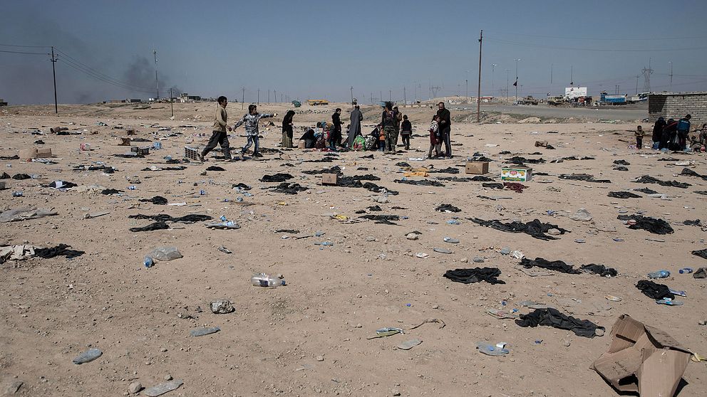 Hundratals med niqabslöjor ligger slängda på marken. Kvinnorna har tvingats täcka sina ansikten under IS våld.