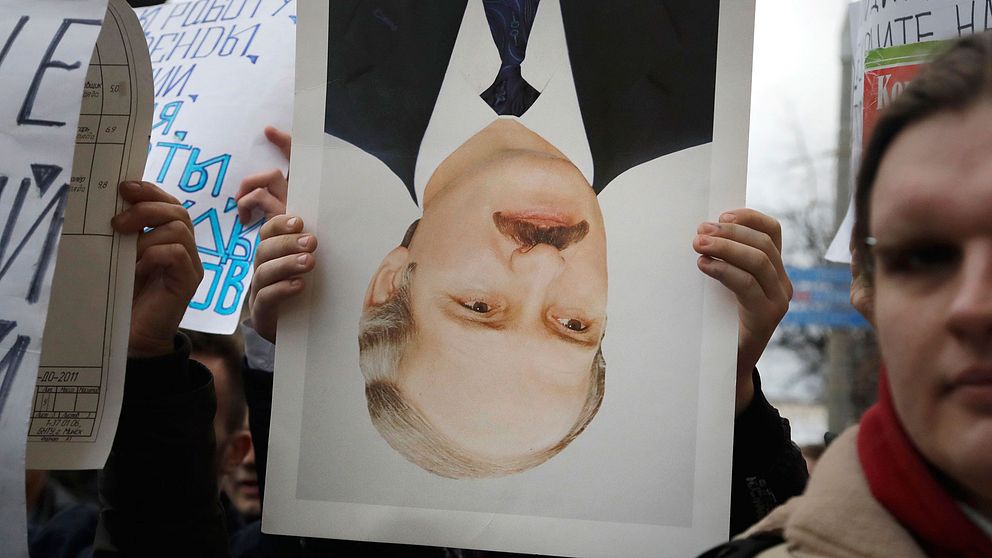En demonstrant håller ett upp- och nedvänt porträtt av president Aleksandr Lukasjenko, ofta kallad Europas sista diktator, under demonstrationerna i Minsk.