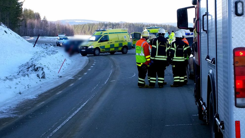 Personal från räddningstjänst och polis står vid olycksplatsen.