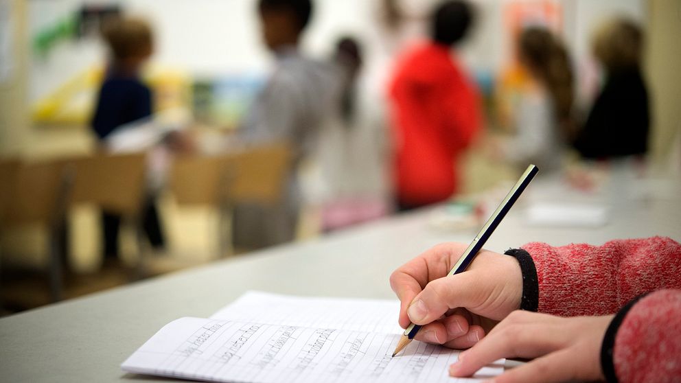 Närbild på elevs hand med penna.