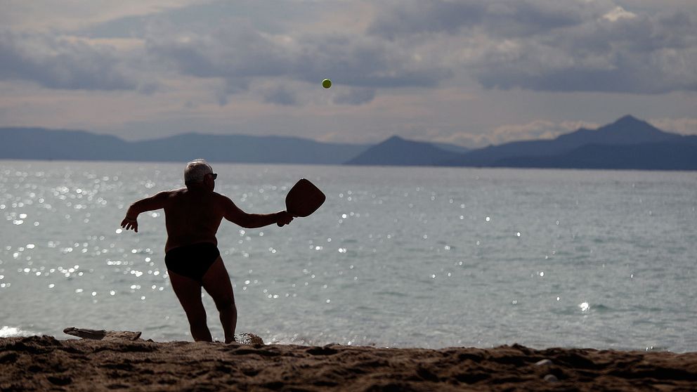 En äldre man njuter av en fin sommardag på stranden.