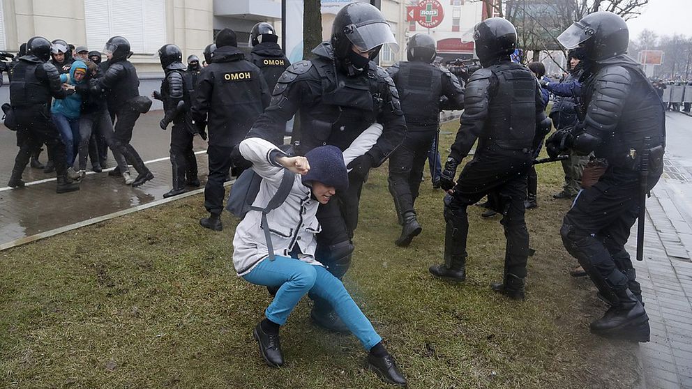 En demonstrant som blir tagen av poliser.