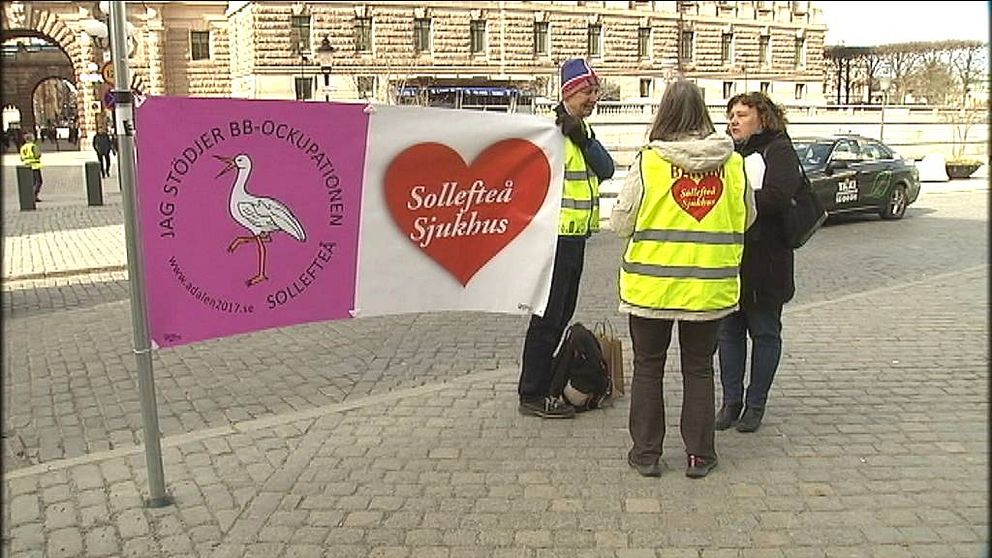 Tre aktivister från Sollefteå med banderoller med texten Jag stödjer BB-ockupationen Sollefteå, framför riksdagshuset.