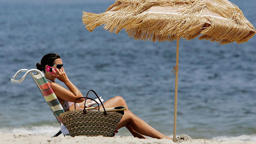 Kvinna ringer på strand.