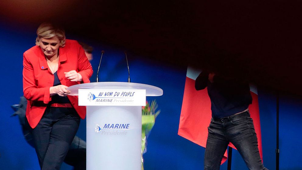 Under Marine Le Pens tal i Paris på måndagen stormades scenen av en aktivist, som snabbt omhändertogs och fördes ut av säkerhetsvakter.