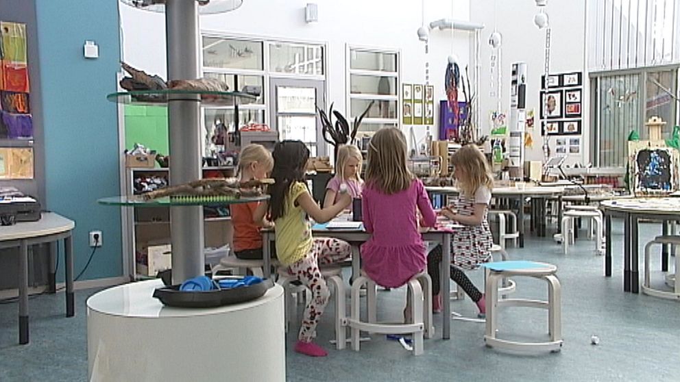 Barn sitter och pysslar runt ett bord