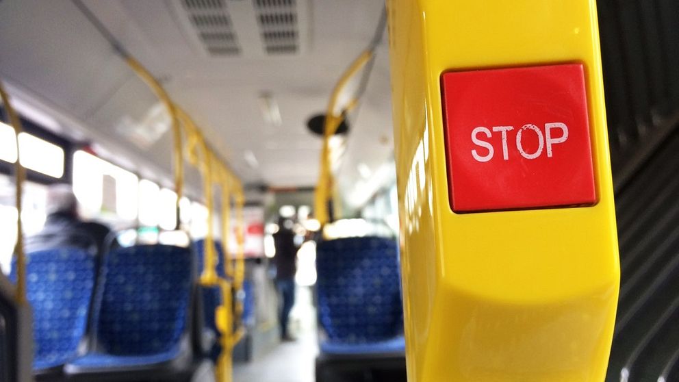 Närbild på stoppknapp på buss