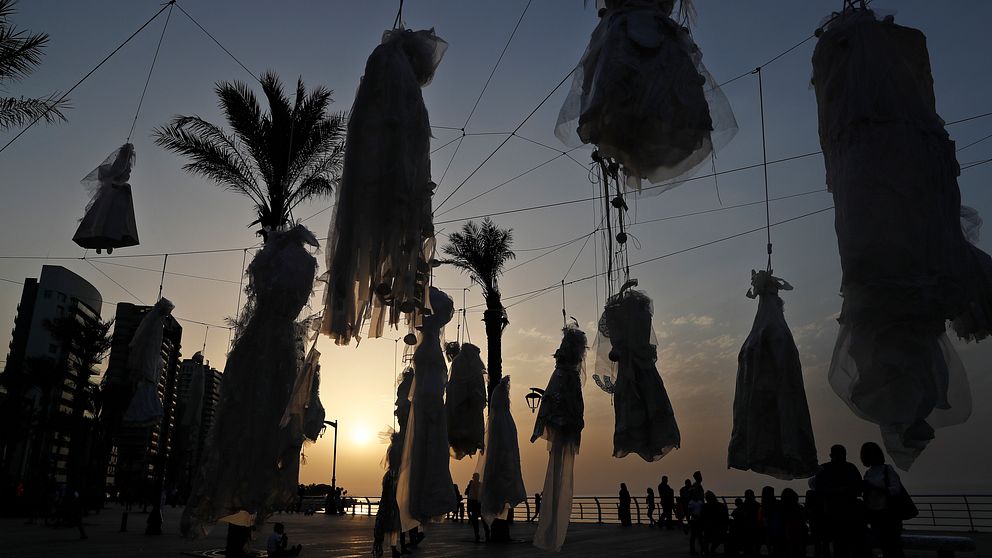 Ett trettiotal brudklänningar upphängda i snaror mellan palmerna på Beiruts strandpromenad.