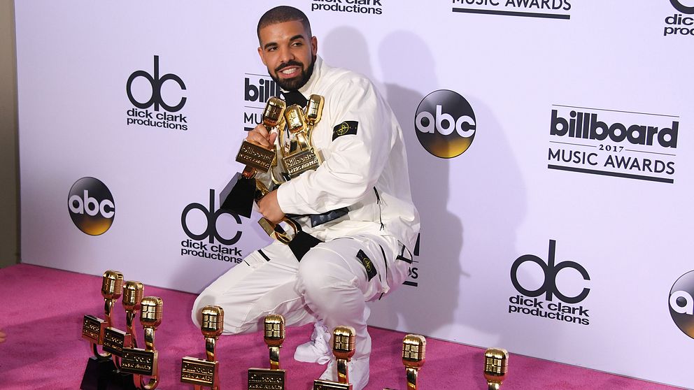 Drake tillsammans med sina 13 priser från Billboard Music Awards.
