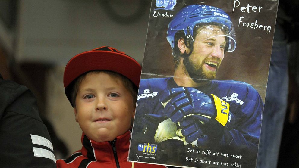 Liten pojke håller i skylt med bild på hockeyspelaren Peter Forsberg