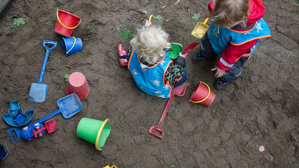 Två barn leker på i en sandlåda