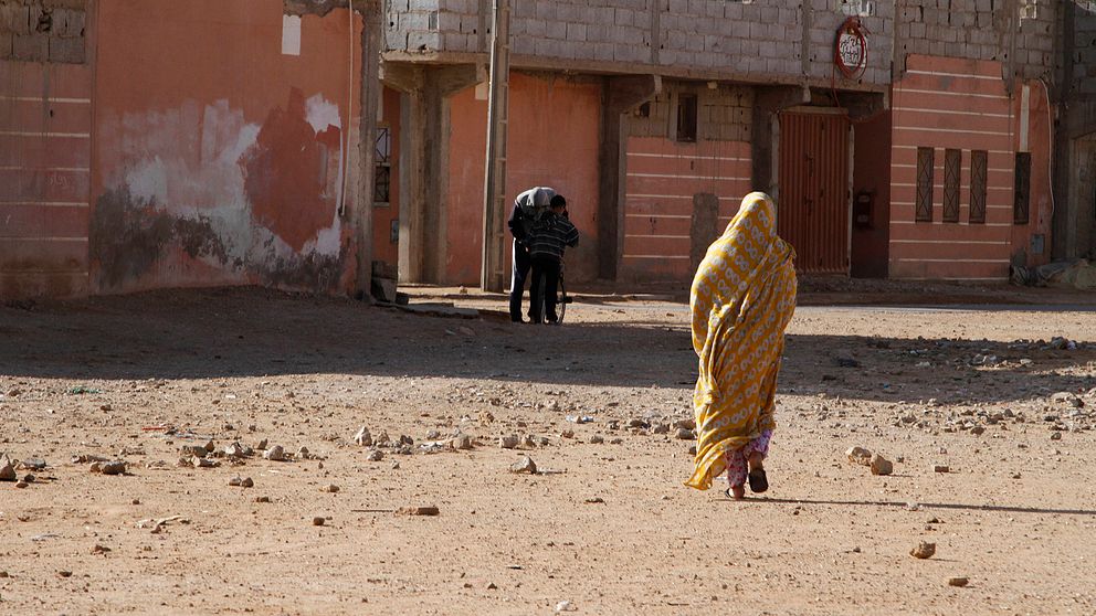 En kvinna vandrar genom ett fattigt område i Västsaharas inofficiella huvudstad al-Ayun