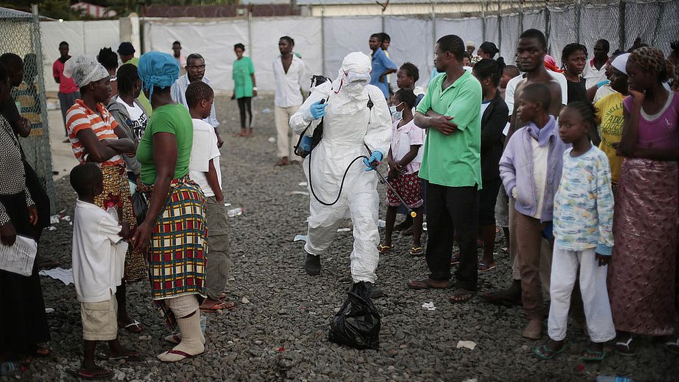 Personer som skrivits ut från en klinik i Liberia sprejas på väg ut därifrån.