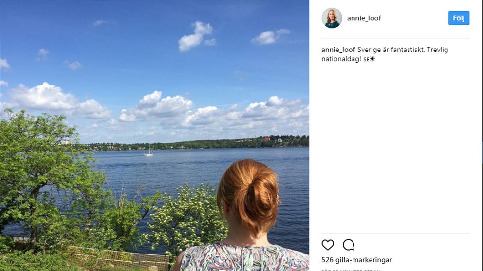 Annie Lööf hyllar Sverige från en klippa vid vatten.