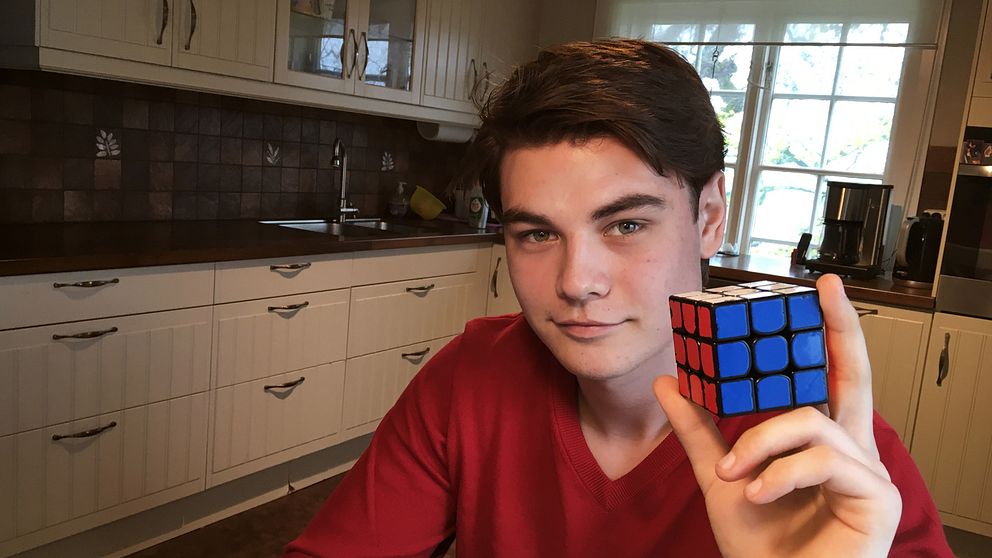 Mattias Uvesten håller upp en Rubiks kub med den blå sidan mot kameran