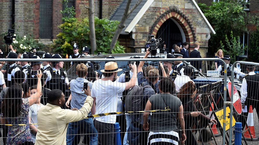 Premiärminister Theresa May eskorteras iväg från Kensington samtidigt som demonstranter vrålar ut sin vrede