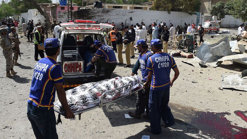 Kroppen från ett av offren i bombdådet i Quetta syns bäras bort av ambulanspersonal.