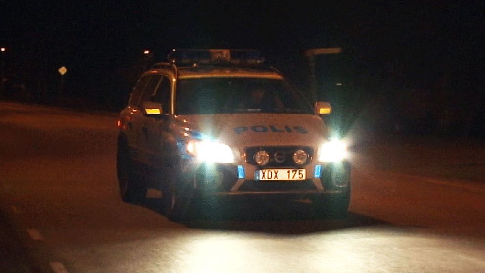En polisbil i mörkret.