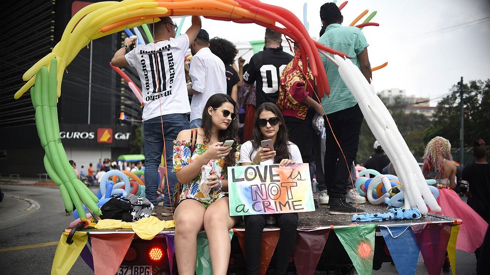 Pridefirare tog sig genom Guatemala City på regnbågsutsmyckade bilar.