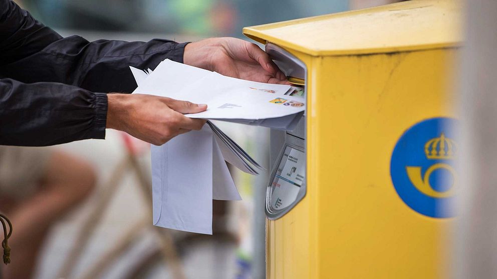 Brev som läggs i en av Postnords gula postlådor.